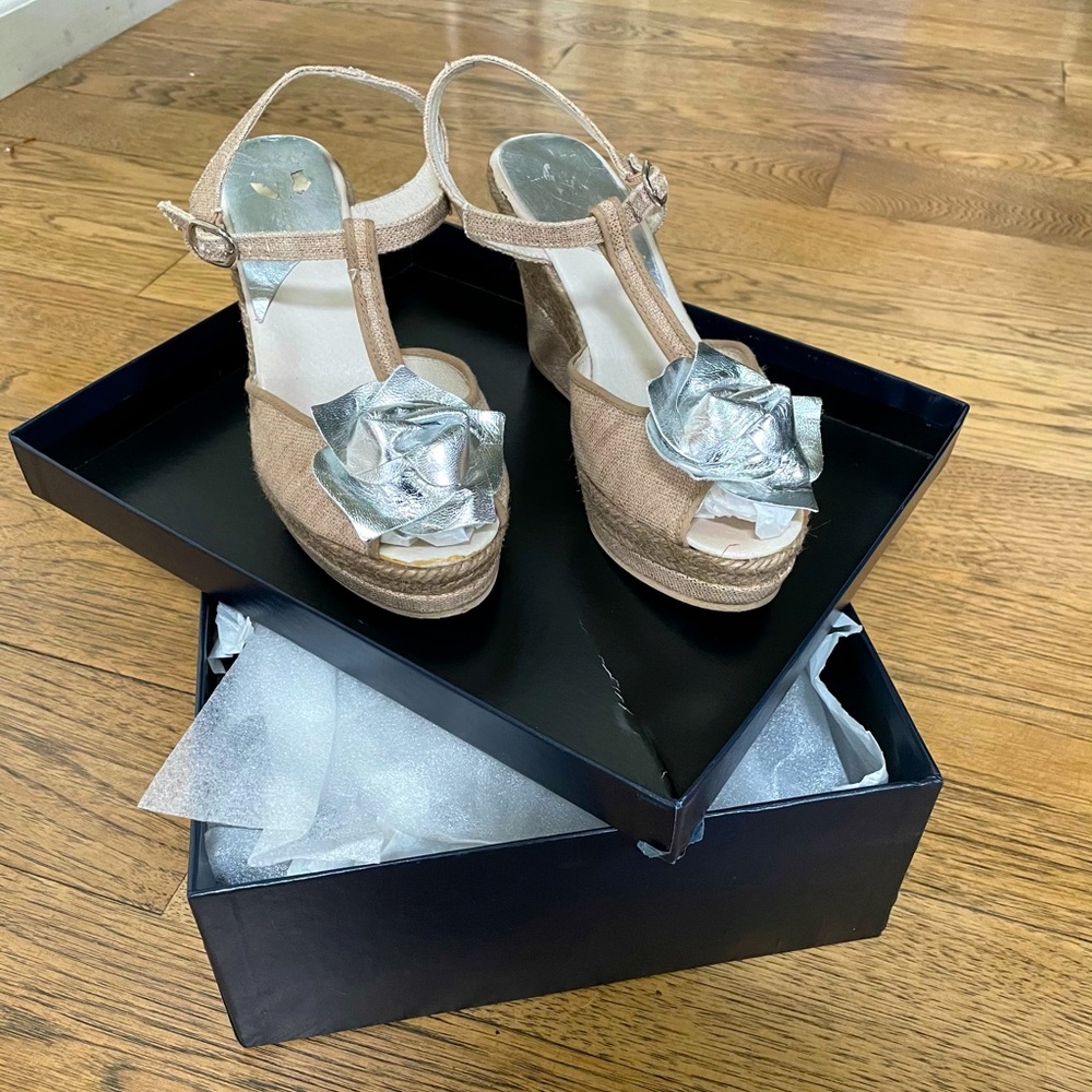 Beige strappy sandals with silver flower detail.